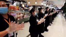 Supermarket staff in Bangkok clap to show support for COVID-19 medical workers
