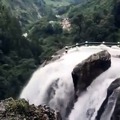 Un camion s'aventure dans un chemin très périlleux au bord d'une falaise et d'une cascade d'eau