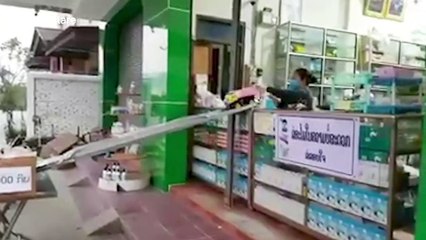 Laotian pharmacy uses DIY slide and toy truck to hand over medicine during coronavirus pandemic