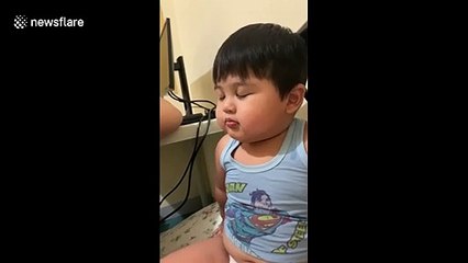 Toddler pretends to be sleeping while mother tells him off