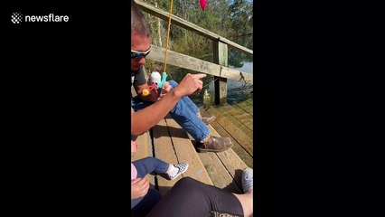 Sweet moment when dad helps baby girl catch a fish