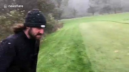 Playing against the odds, two men in Chicago play golf despite heavy rain storm