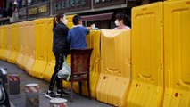 Wuhan residents shop across tall barriers as the city lifts restrictions