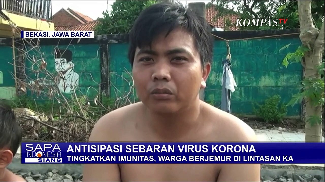 Tingkatkan Imun, Warga di Bekasi Berjemur di Atas Rel Kereta Api