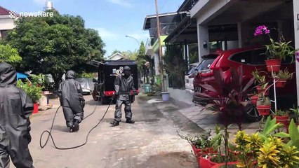 Police in Indonesia spray disinfectant on homes amid coronavirus pandemic