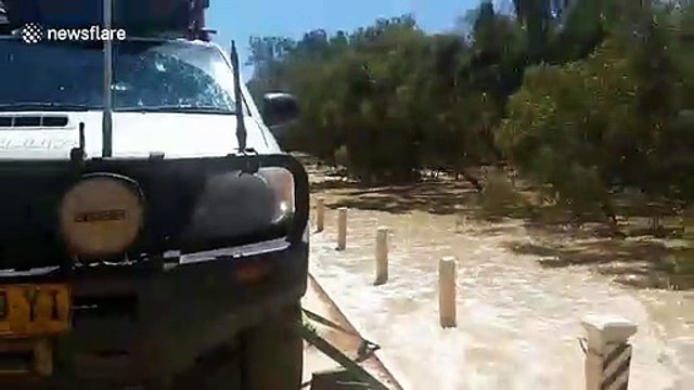 Vehicle drives through flooded roads after river overflows in western Queensland, Australia