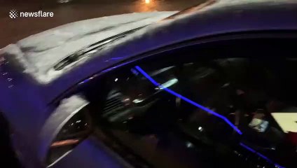Watch South Dakota driver smash thick layer of ice off his car as extreme freezing rain continues.