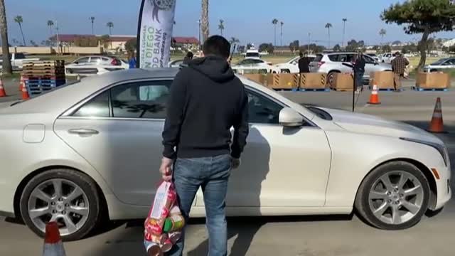 Voluntarios reparten comida a las familias más pobres en las inmediaciones de San Diego