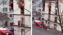 Un pompier sort une femme d'un appartement en feu