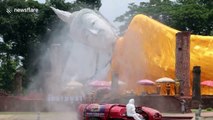 Customised vehicles used to spray sanitising liquid on buildings in Thailand