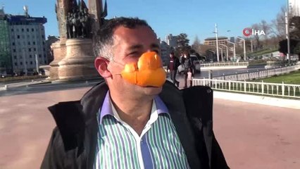 Portakaldan yaptığı maske ile türkü söyleyerek Taksim'de yürüdü