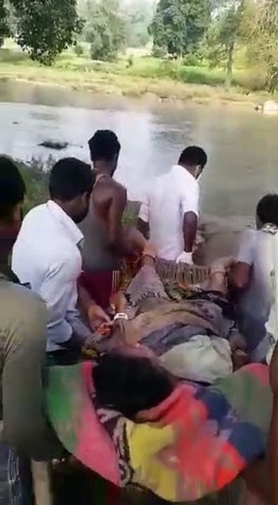 जमीन पर उतर आए राम और कृष्ण, प्रसव पीड़ा से कराह रही महिला को खाट पर लेटाकर नाला कराया पार
