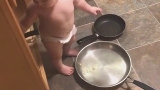 Un bébé sur le point de cuisiner essaye de ne pas rire