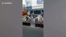 Filipino motorcyclists are punished to walk along streets with helmets after being caught riding without protective gears