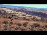 Guy Does Wheelie on Bike Over Mountain Road With Stunning Backdrop of Canyons
