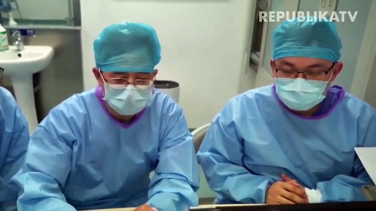 Pekerja medis mengecek kondisi pasien virus cor...