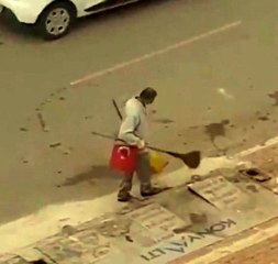 Yerde bulduğu Türk bayrağını süpürgesine takarak işine devam etti