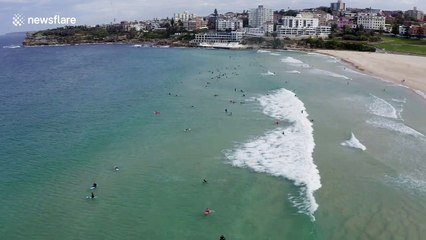 Surfers and swimmers hit the sand after Bondi Beach reopens in Sydney