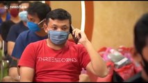 Indonesian care workers wear protective gear while taking turns to cut each other's hair during COVID-19 pandemic