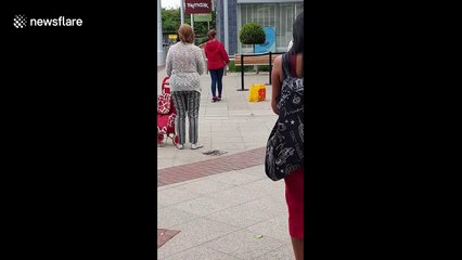 Weight it out: Woman performs exercise routine including PUSH-UPS while queuing at London shopping centre
