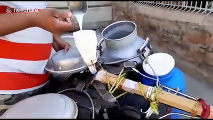 Indian man uses social distancing milk gun to serve customers