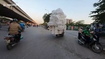 Ridiculously overloaded tricycle carries countless foam boxes on the streets of Vietnam
