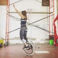 Woman Spins Two Hula Hoops While Balancing on Unicycle
