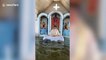 Filipino priest gives service in flooded church while parishioners attend in boats