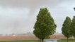 Powerful tornado spins through field