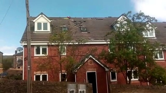 Man on roof throwing tiles