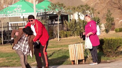 Practical joker dressed as old man pranks passers-by with break dancing