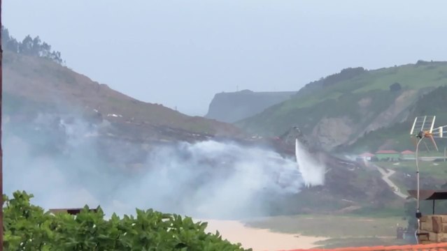 Labores de extinción del incendio en la playa de Rodiles