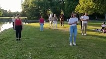 Deux agents de police en chevaux participent à un cours de salsa dans un parc.