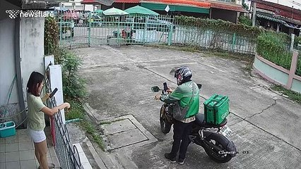 Unexpected moment woman's headphones get caught on gate pulling her to the ground