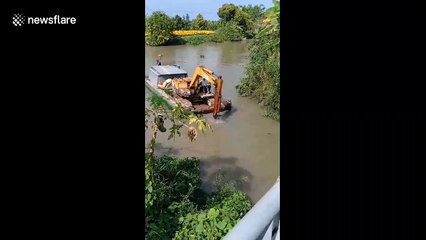 Ingenious excavator driver uses bucket to pull boat along river in Vietnam