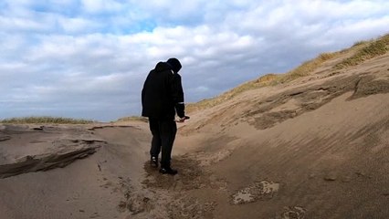 Shovelling with a military shovel on the coast of the Northern sea (movie)