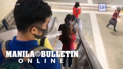 Commuters flock at the MRT-3 while observing social distancing