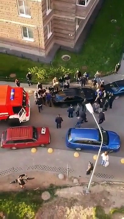 Des personnes soulèvent une voiture pour laisser passer un camion pompier