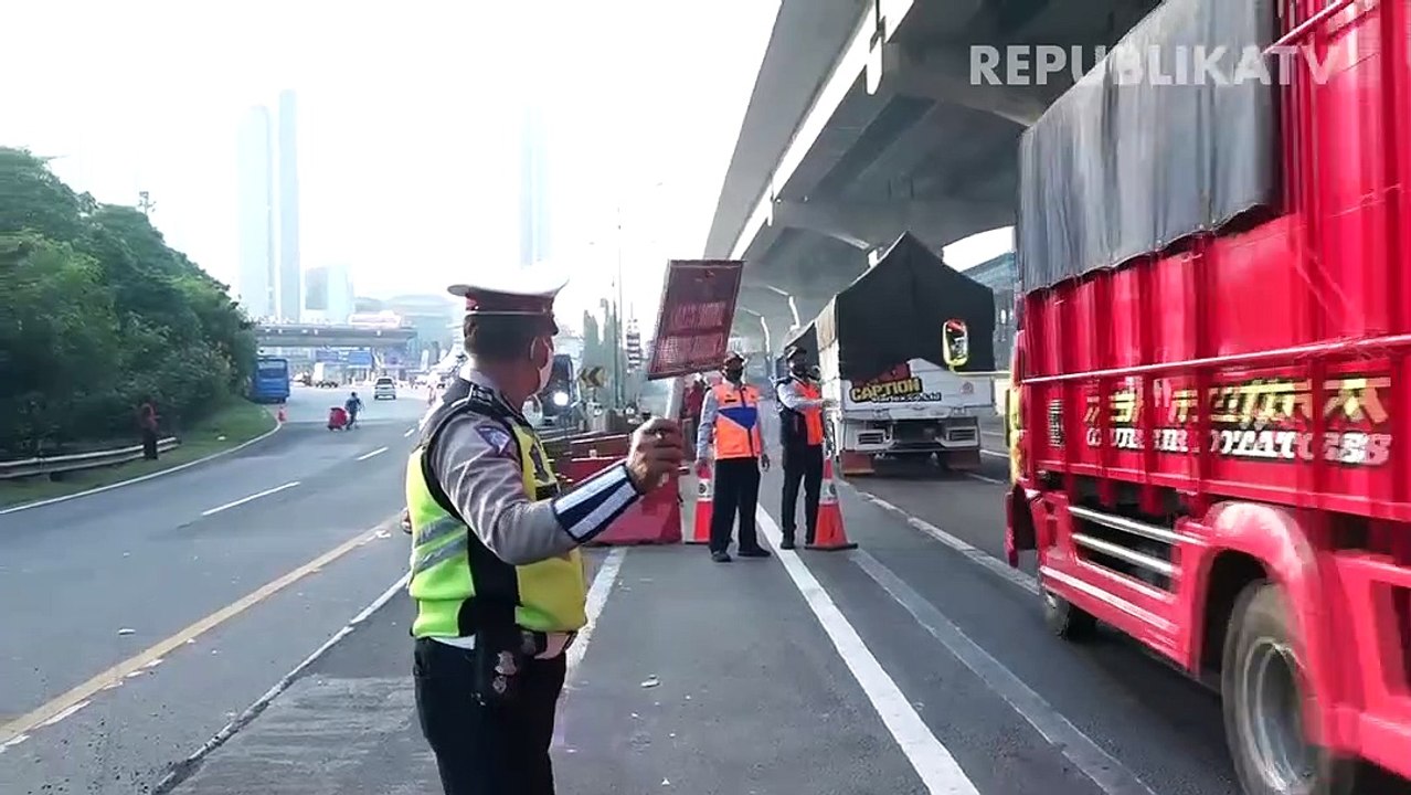 Petugas melakukan pengecekan kepada pengendara dengan plat nomor luar daerah yang melintasi Check Point PSBB di kawasan Kalimalang, Jakarta.