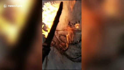 Creative Chinese man uses flaming wooden stick to draw on wall
