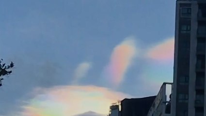 Spectacular rainbow clouds form over city