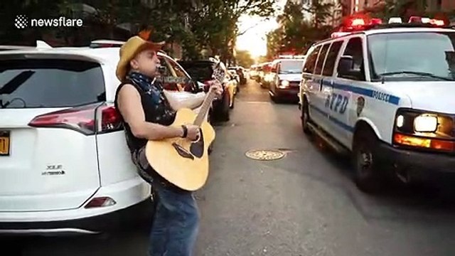 New York: Man plays Blowin' In The Wind as police convoy follows protest march against police brutality