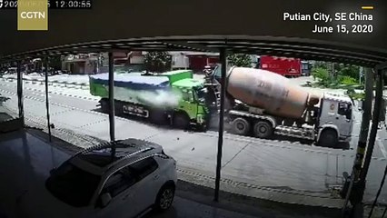 Une voiture écrasée entre deux camions