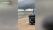 Spinning waterspout tornado looms over Thai coast as beachgoers play in sea