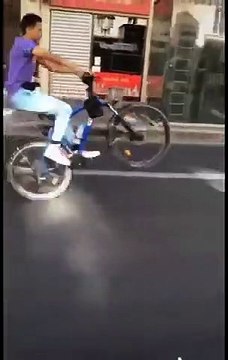 Ce policier tombe en arrière en tentant un une roue en vélo !