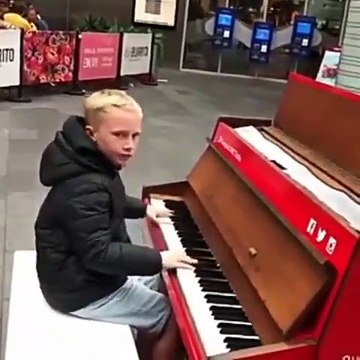 Un jeune garçon joue Children de Robert Miles au piano dans la rue