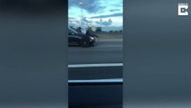 Ce conducteur croises un homme couché sur le capot d'une voiture sur l'autoroute
