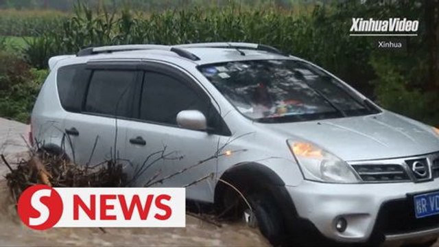 Driver stuck in a flooded road in China rescued by firefighters