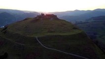 Drone footage captures picturesque sunset as it silhouettes medieval castle in Wales