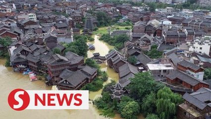 Firefighter uses his back as bridge for trapped villagers in flood